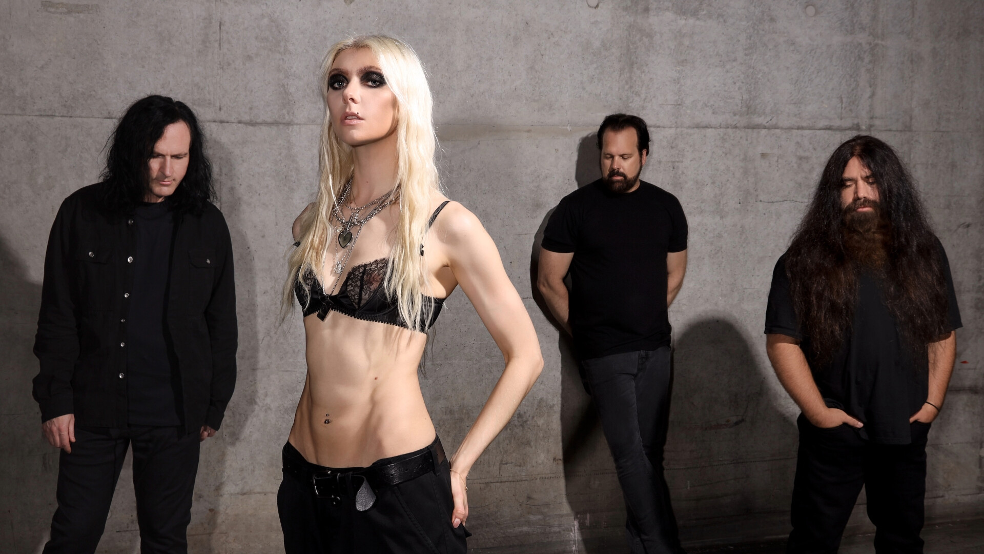 The Pretty Reckelss stehen vor einer Betonwand