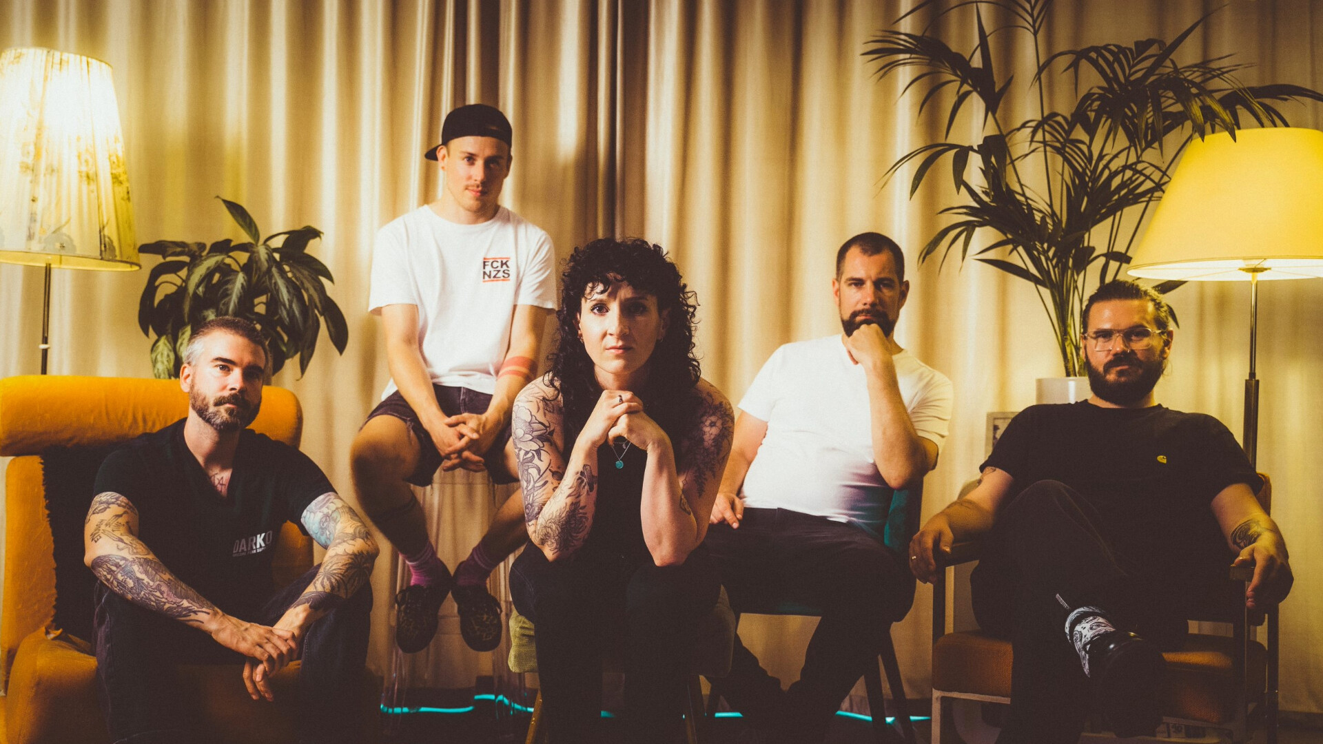 Die Band posiert in einem Vintage Wohnzimmer