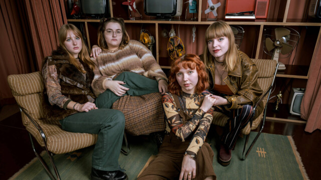 Die 4 Mitglieder der Band sitzen in eine Vintage Wohnzimmer