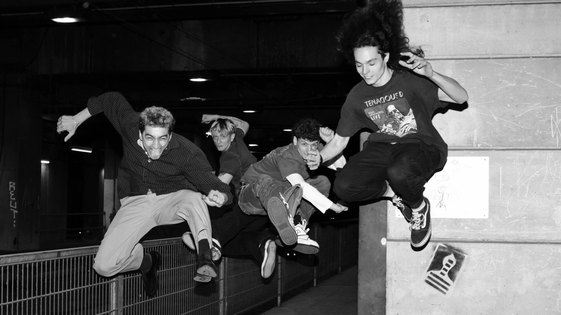 Schwarzweiß Die Band Springend vor einer Säule