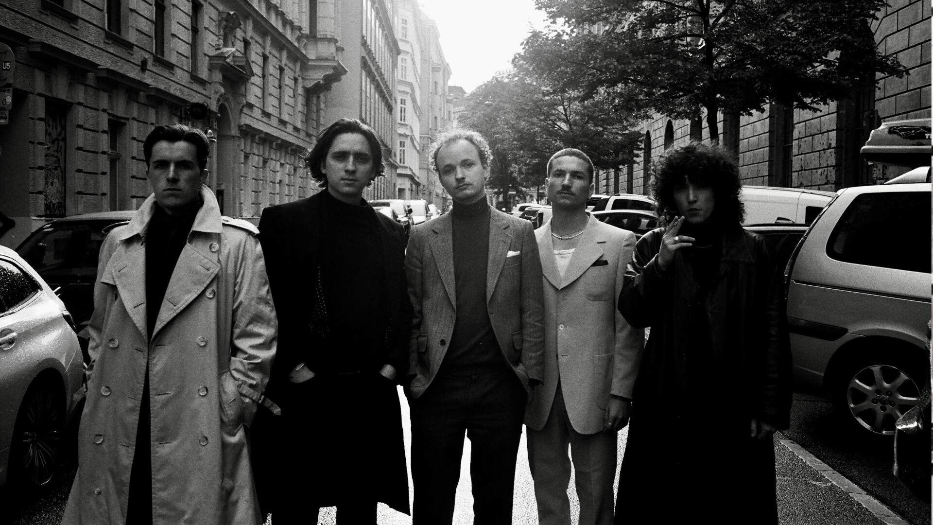 Die Band Julia Effekt auf einer Straße mit parkenden Autos in schwarzweiß