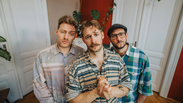 Die 3 Männer stehen in einem herbstlichen Park mit Grafitti