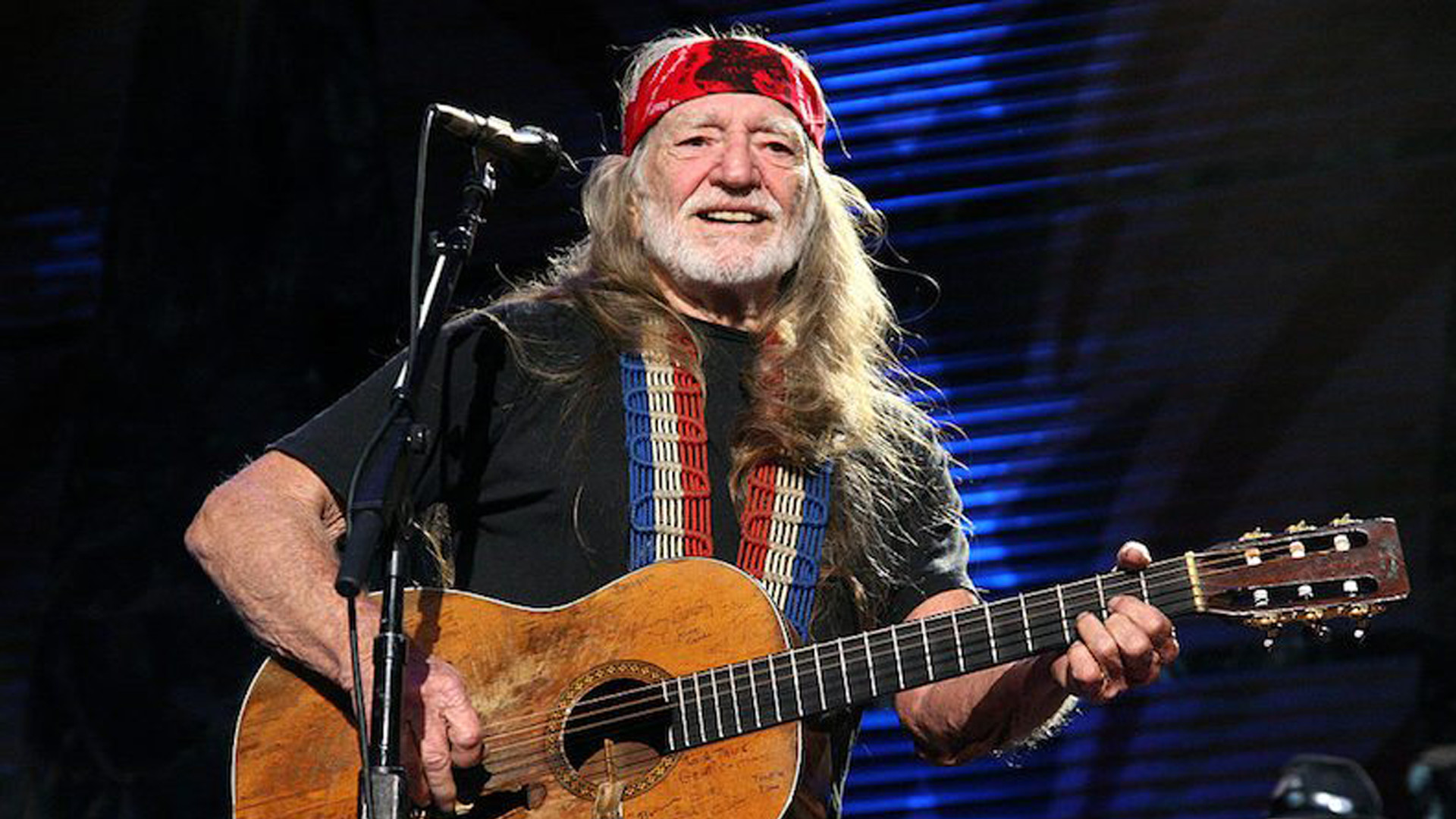 Der Country-Sänger Willie Nelson mit Akkustikgitarre auf der Bühne
