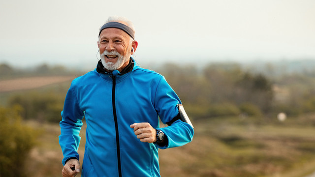 Älterer Mann in Laufkleidung joggt durch Natur