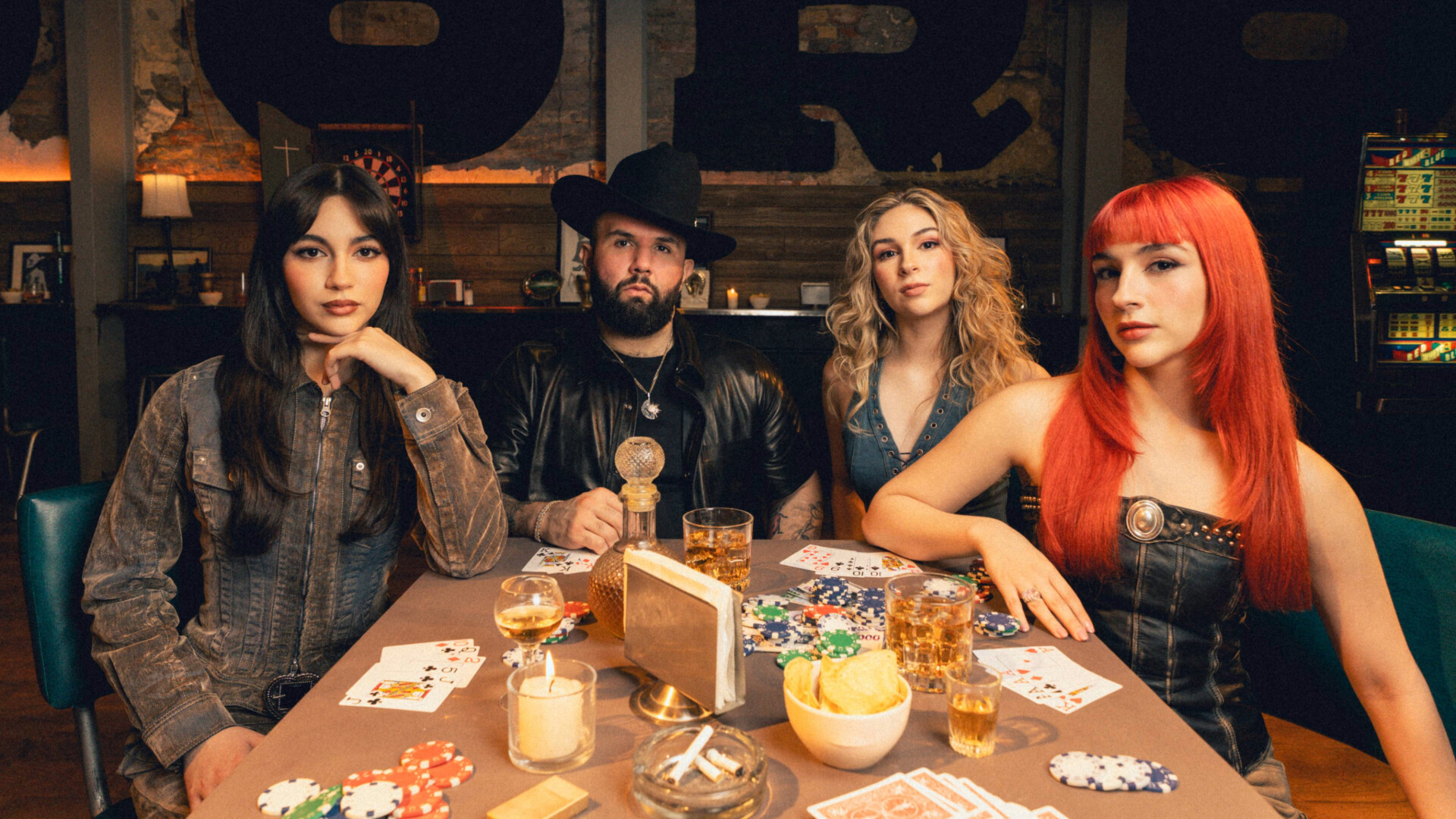 Die Bandmitglieder von The Warning mit dem Musiker Carin Leon an einem Pokertisch