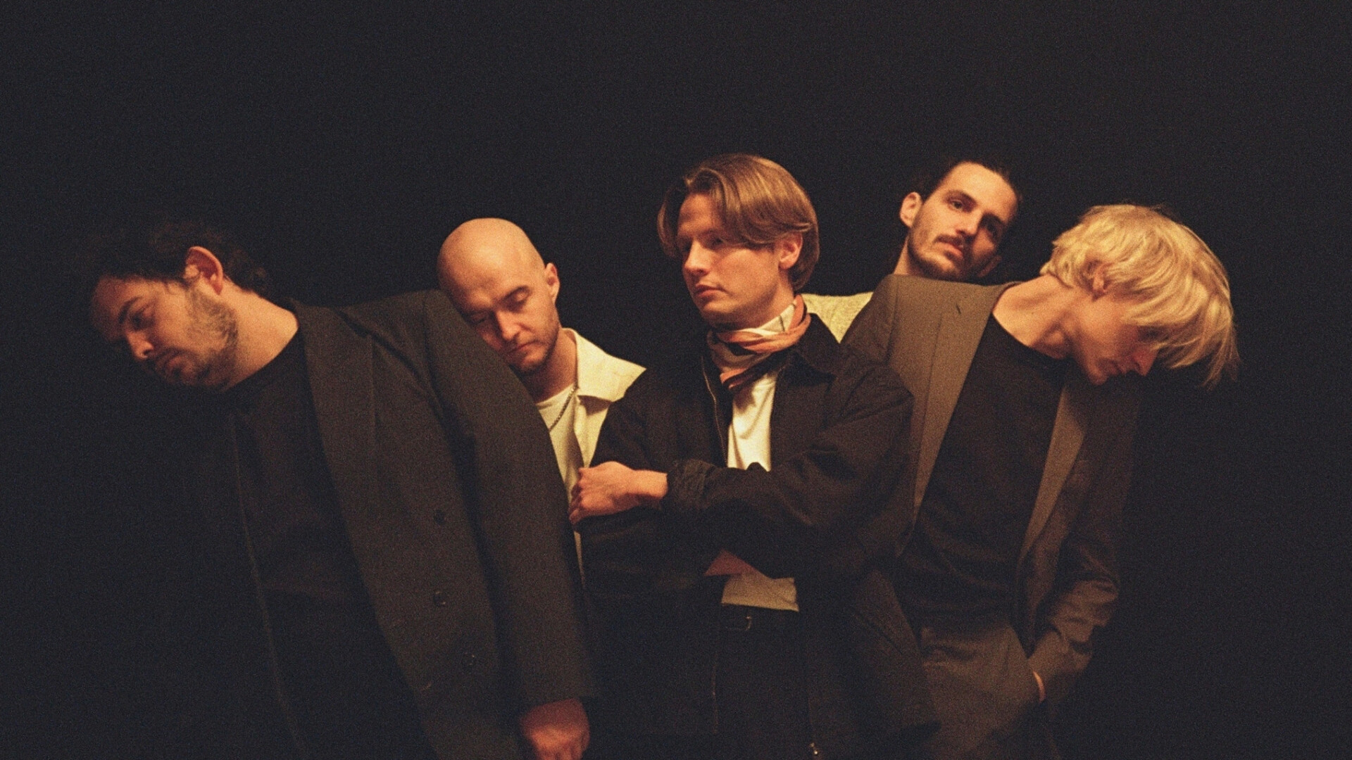 Band steht im dunklen. Beleuchtet von gelbem Licht