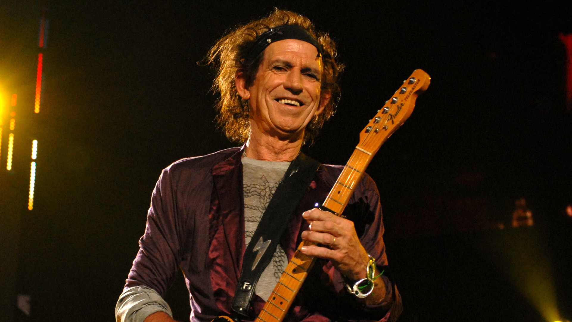 Keith Richards spielt Gitarre auf der Bühne und lacht