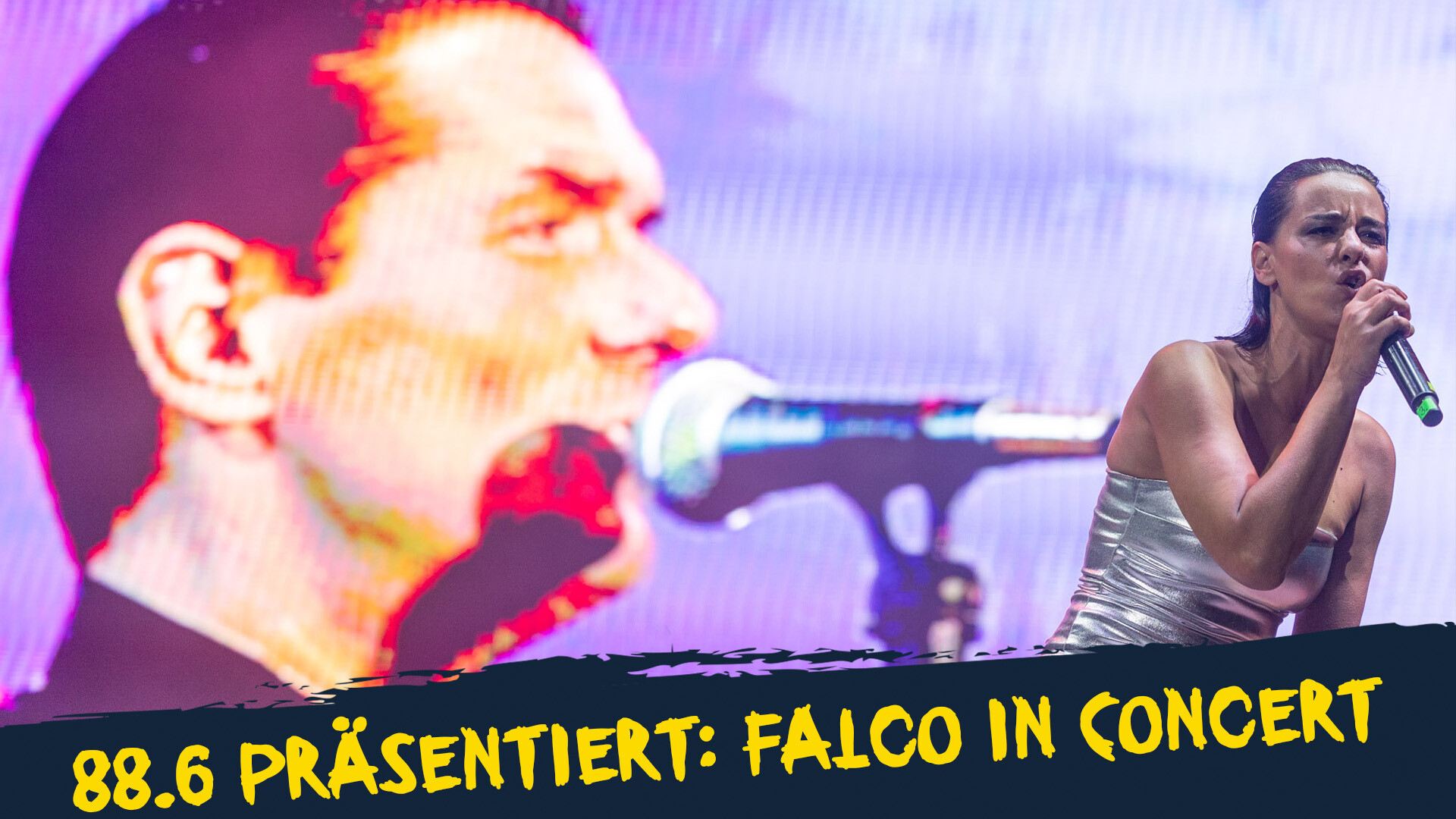 eine singende Frau vor einem Falco Bild eine singende Frau vor einem Falco Bild