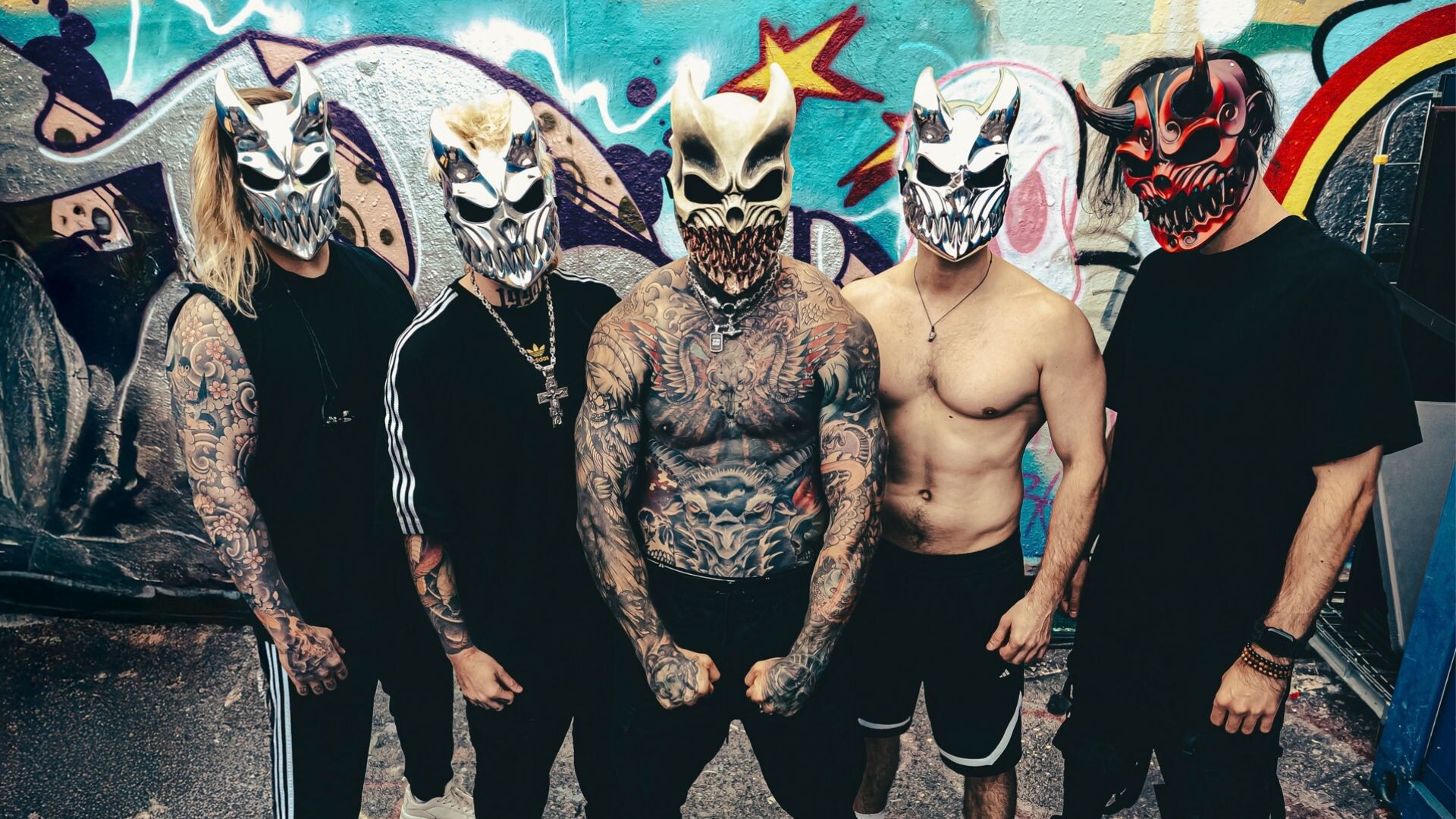 Slaughter To Prevail mit ihren Masken vor einer Graffity Wand