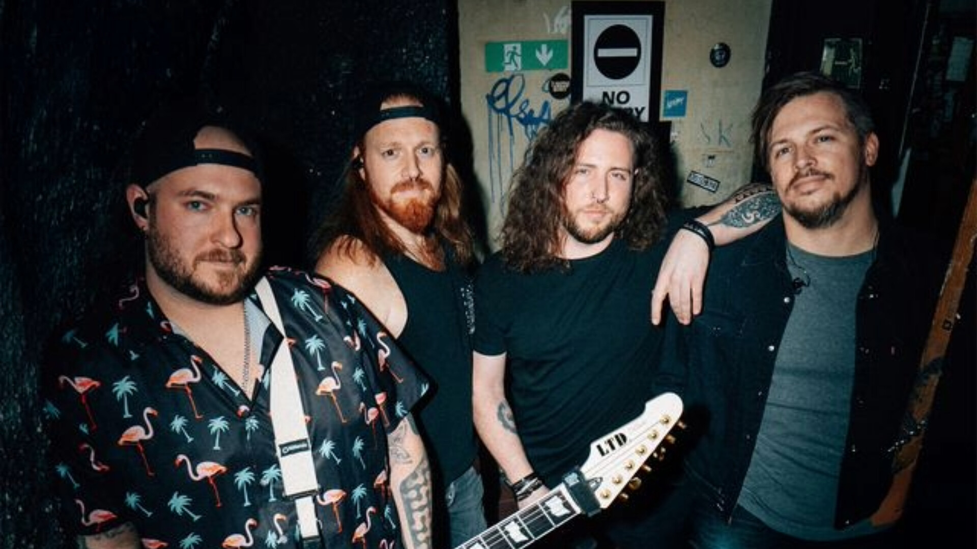 Die Band posiert in einem dunklen Raum