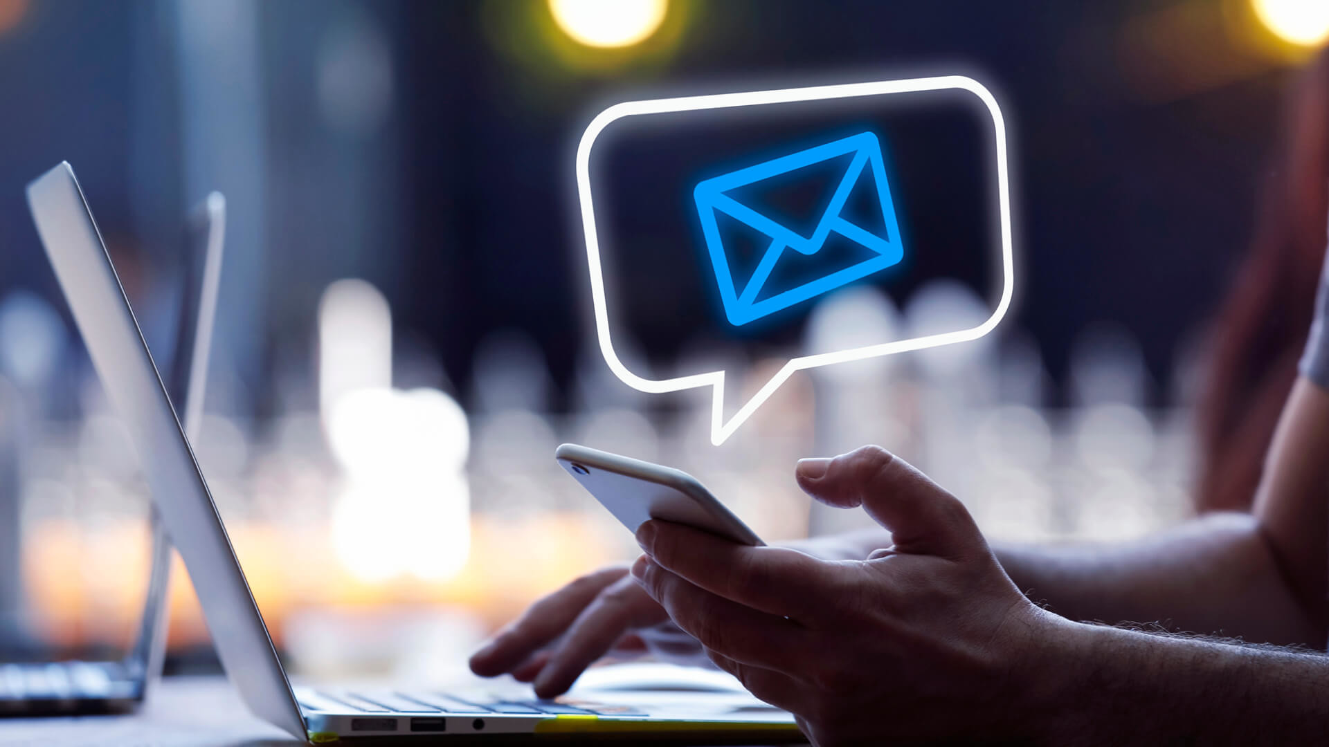 Email Ein Laptop und ein Smartphone, die jemand bedient der gerade eine E-Mail erhalten hat