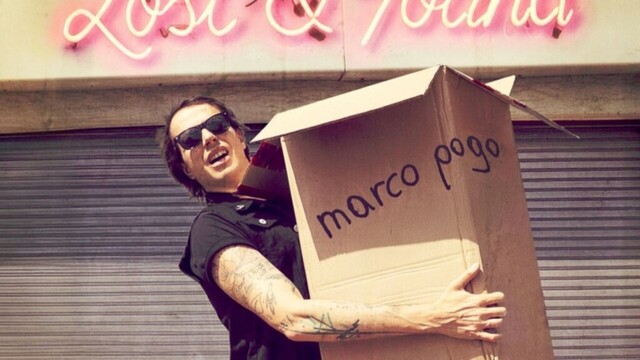 Marco Pogo mit Umzugskarton vor einer Wand
