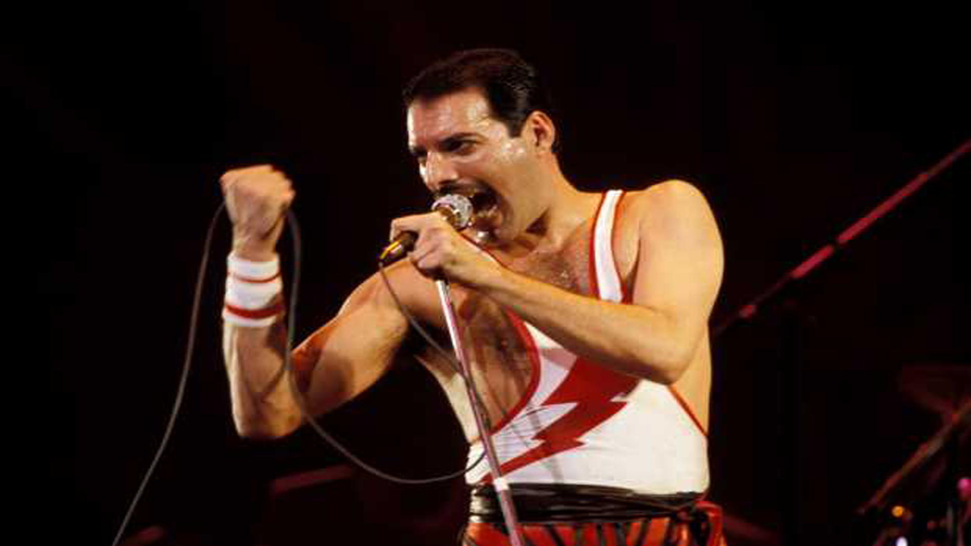 Freddie Mercury der Frontman von Queen singt in ein Mikrofon bei einem Konzert auf der Bühne