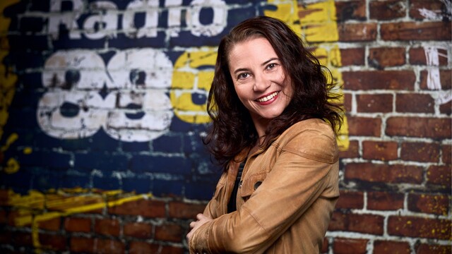 Moderatorin Lydia Veigl steht vor einer Radio 88.6 Backsteinwand