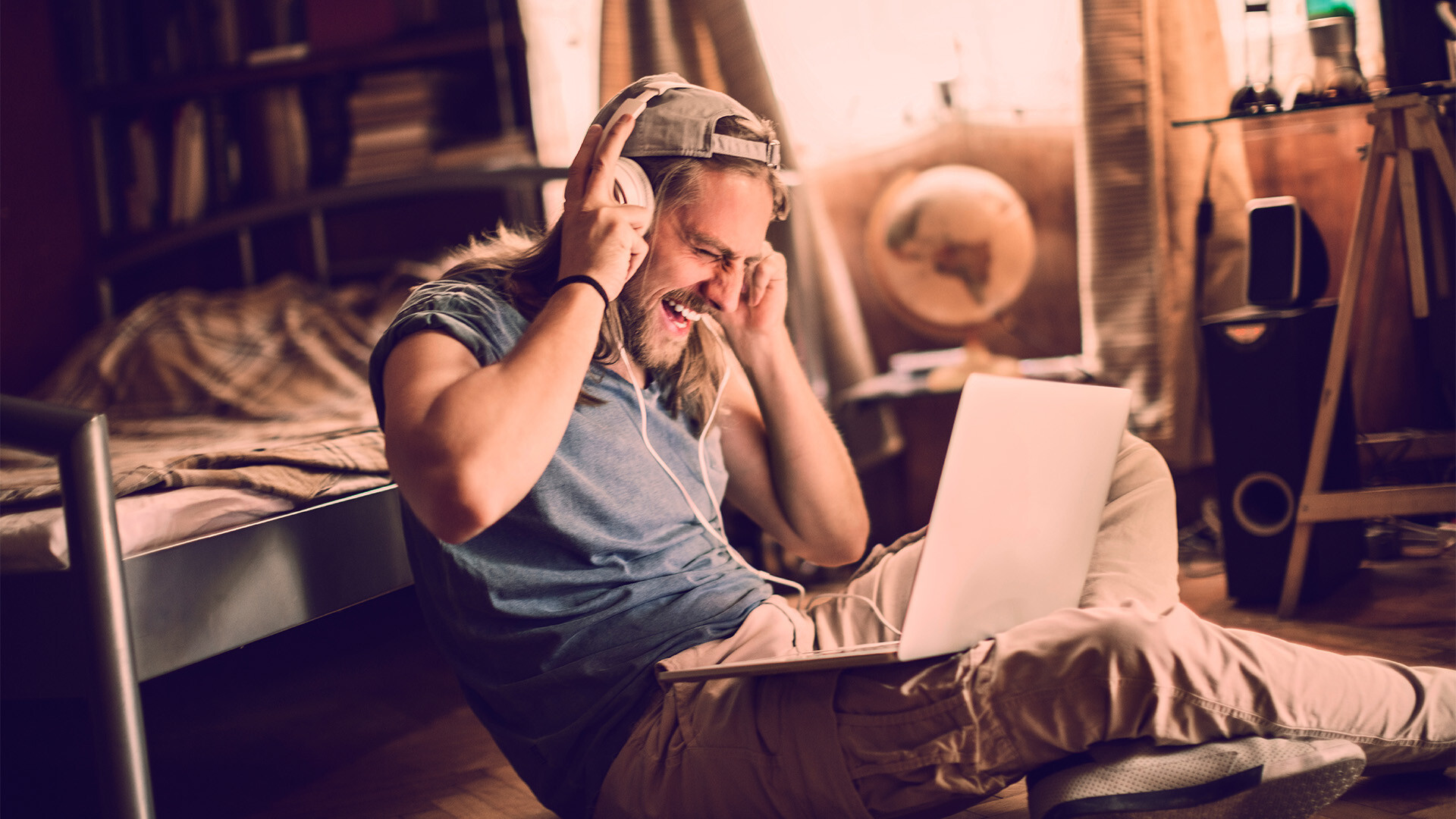 Ein Mann mit Kopfhörern und Laptop