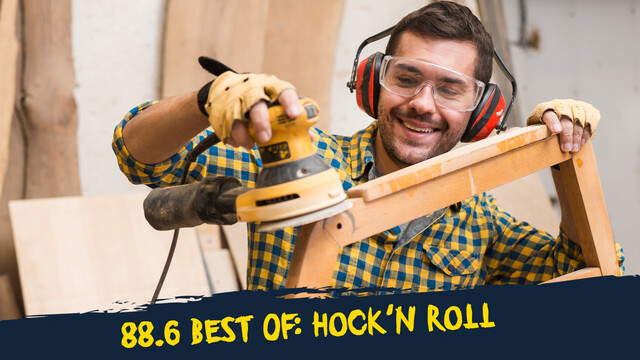 Ein Mann mit Schutzbrille und Gehörschutz, der mit einer Maschine Holz abschleif