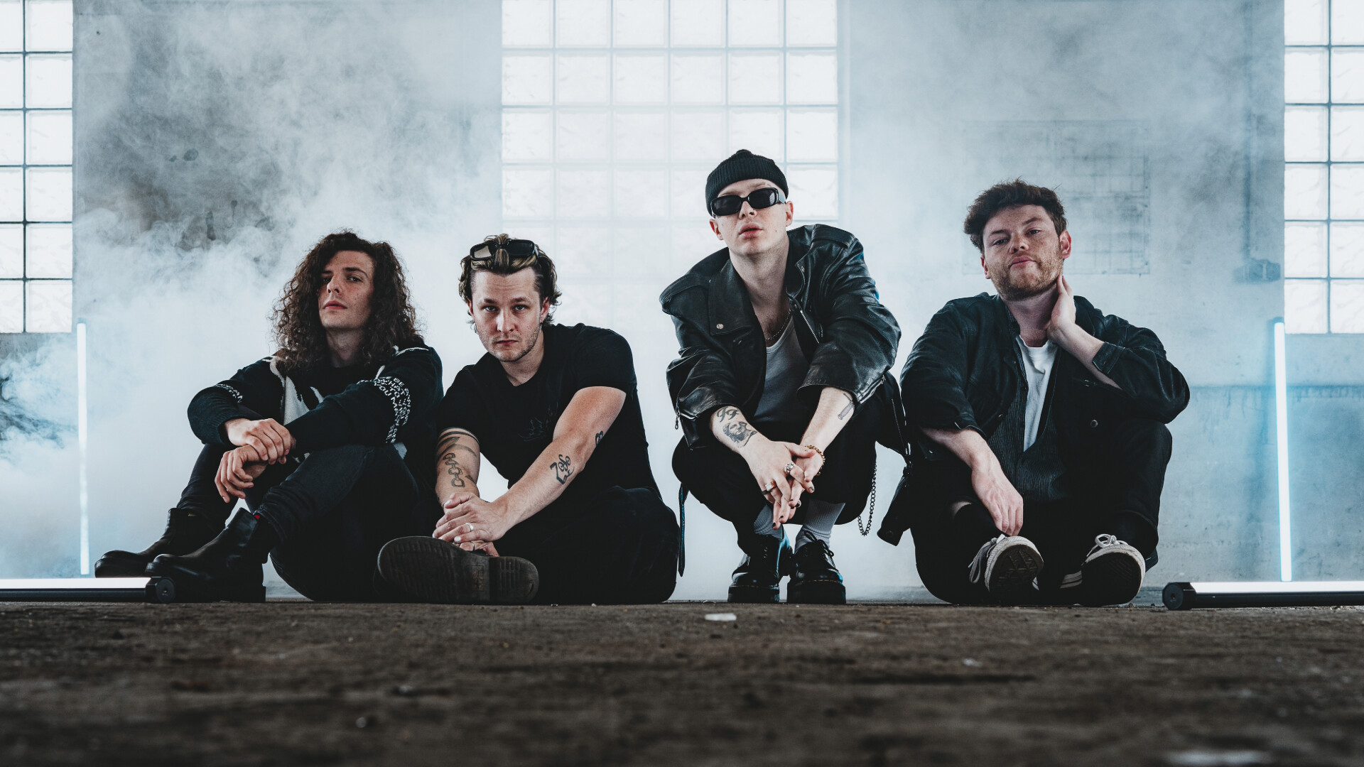 Die Band sitzt in Nebelschwaden in einer Industriehalle