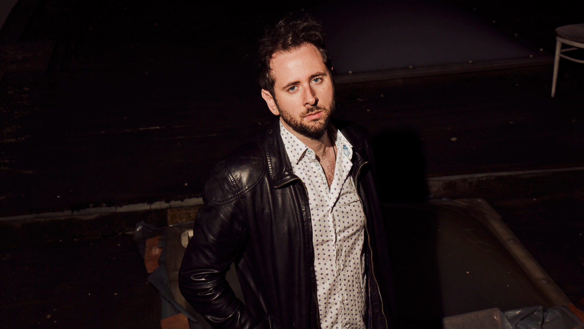 Greyshadow steht in hemd und Lederjacke bekleidet